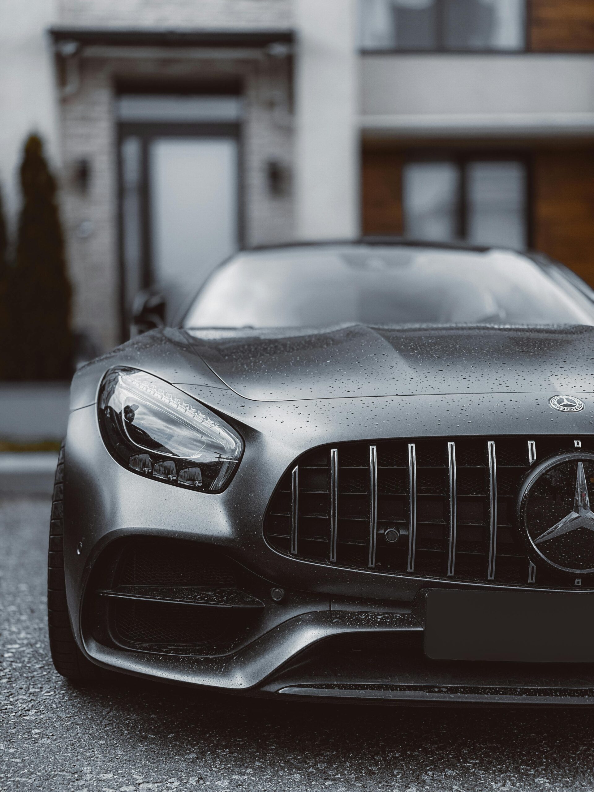 Close-up of a sleek Mercedes Benz car front, showcasing luxury design in an urban background.